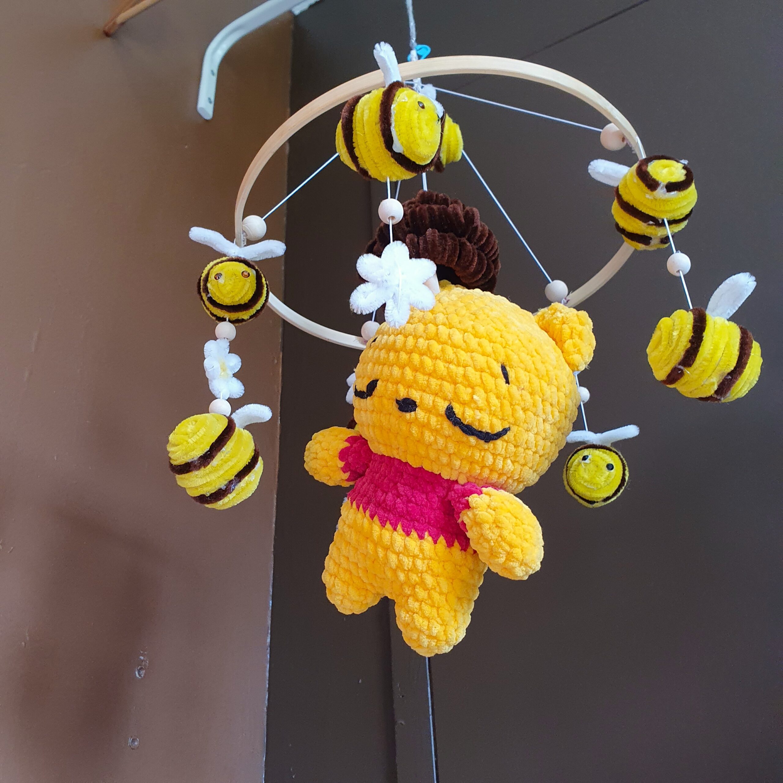 le mobile winnie vu de dessous aec ces abeilles et ses fleurs qui tourne autour de la peluche winnie centrale